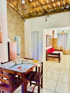 a dining room with a table and chairs and a bedroom at Casa Adriê in Itacaré