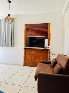 a living room with a couch and a flat screen tv at Casa Adriê in Itacaré