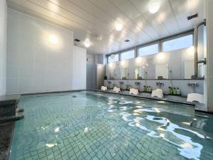 a bathroom with a swimming pool with a mirror at Hotel 1-2-3 Takasaki in Takasaki