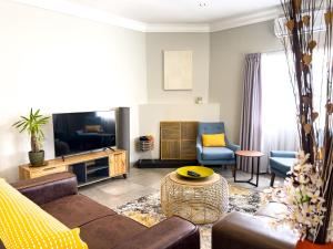 a living room with a couch and a tv at Nest - The Homestead in Howick