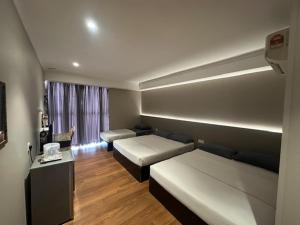 a living room with two beds and a couch at Li Garden Hotel in Pasir Gudang