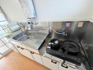 a kitchen with a stove and a sink at テラスリバーサイド 301 in Miyazaki