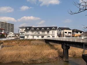 a large white building with a bridge over a river at テラスリバーサイド 301 in Miyazaki