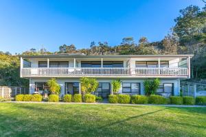 a large house with a balcony and a yard at Hahei Island Views in Hahei