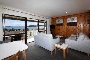 a living room with two white couches and a balcony at Hahei Island Views in Hahei