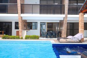 a swimming pool in front of a building at Bangalô Camboinha triplex in Cabedelo