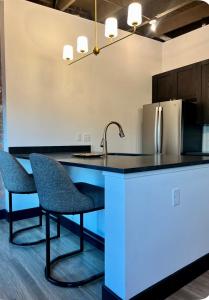 a kitchen with a counter with two chairs and a sink at Brick & Bed Riverfront Lofts, T 202 in Saint Louis +4 photos