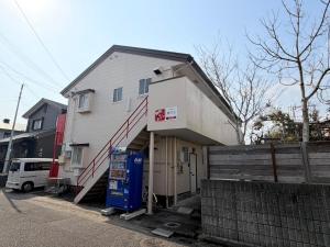 a house with a staircase leading up to a garage at パームハウス 202 in Miyazaki