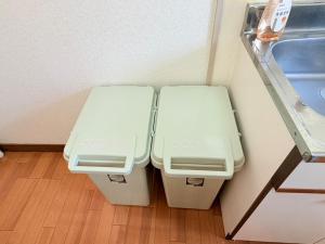 two white toilets in a corner of a room at パームハウス 202 in Miyazaki