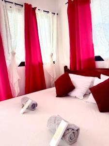 a bedroom with red curtains and a bed with towels on it at Placido's Vacation Home in Puerto Galera +163 photos