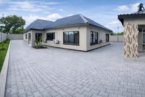 a house with a brick driveway in front of it at Casuarina Apartments in Livingstone