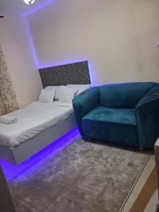 a bed and a couch in a room with purple lights at BoniMark in Machakos