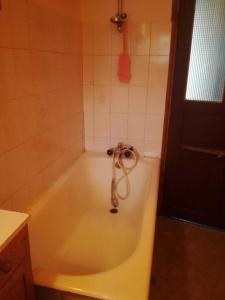 a bath tub with a hose in a bathroom at Chez NIKI in Rieutort +38 photos