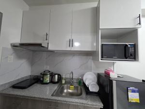 a kitchen with a sink and a microwave at Gem's Silid Tulugan in Cebu City