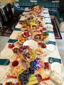 a long table with many plates of food on it at Guest House Jekshen in Imeni Karla Marksa +88 photos