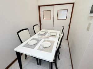 a white table with chairs and plates on it at パームハウス 203 in Miyazaki +14 photos