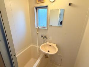 a bathroom with a sink and a bath tub at パームハウス 203 in Miyazaki