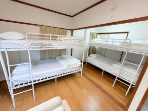 two bunk beds in a room with wooden floors at パームハウス 203 in Miyazaki