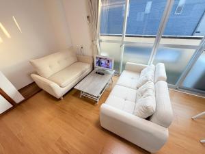 a living room with a white couch and a table at パームハウス 203 in Miyazaki