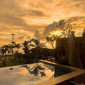a view of a sunset from a resort with a pool at Solsticio Azzul Beach Resort in Pandan