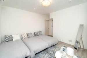 a white bedroom with a bed and a mirror at 不二咲 in Fujiyoshida