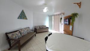 a bedroom with a bed and a couch and a window at Pousada Vila ÁguaMar in Itapoa