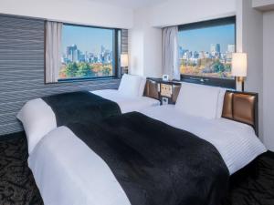 two beds in a hotel room with large windows at APA Hotel Tokyo Ojima in Tokyo