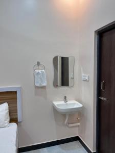 a bathroom with a sink and a mirror on the wall at VV Guest House & Rooms in Tiruvannāmalai +96 photos