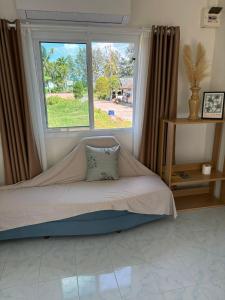 a bed in a room with a large window at Penn house with shared pool in Ko Raeng
