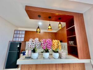 a kitchen with three vases of flowers on a counter at Agustik Villas in Badung