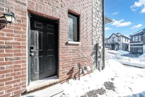 a black door on the side of a brick building at Newly Renovated 2BR Basement Suite, Private Entry in Pickering