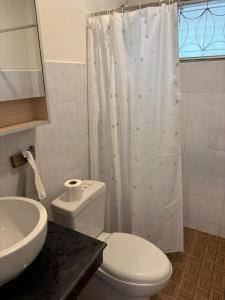 a bathroom with a toilet and a white shower curtain at Penn house with shared pool in Ko Raeng +17 photos