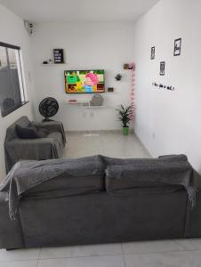 a living room with a couch and a tv at Mirian nascimento in Camaçari