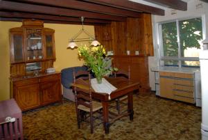 a kitchen with a table with a vase of flowers on it at Ca la Paula in Pla del Panadés