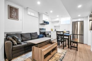 a living room with a couch and a kitchen at Newly Renovated 2BR Basement Suite, Private Entry in Pickering