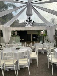a marquee with white tables and white chairs at The Lumber with Private Pool in Masjid Tanah