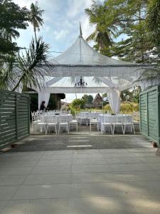 a group of tables and chairs under a white tent at The Lumber with Private Pool in Masjid Tanah