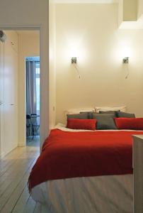 a bedroom with a large bed with red pillows at Apartment Bac St. Germain in Paris