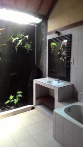 a bathroom with a bath tub and a fish tank at Kubu shanti 1 in Ubud +4 photos