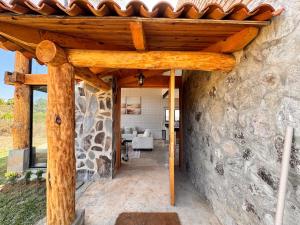 a stone building with a wooden pergola at BOSK TAPALPA - Cabaña en Tapalpa in Tapalpa
