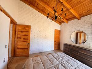 a bedroom with a large bed and a mirror at BOSK TAPALPA - Cabaña en Tapalpa in Tapalpa