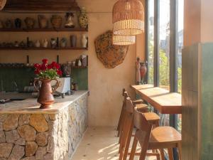 a kitchen with a counter and a table and chairs at The Petra Boutique Studios in Ko Tao