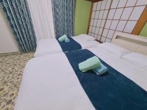 two beds in a hotel room with white sheets at 池袋1F 2bedrooms Suite Cozy for 1-4 guests in Tokyo