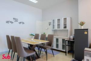 a dining room with a table and chairs and a refrigerator at Dream Home in Hat Yai in Ban Kohong