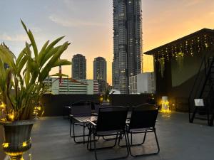 a patio with chairs and a table and a city skyline at Poshtel 56 in Bangkok