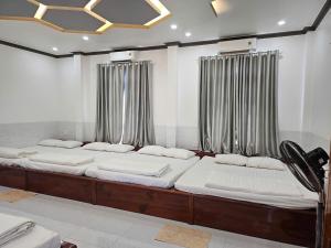 two large beds in a room with curtains at Lê Gia HOUSE KG in Kiên Lương