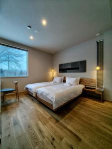 a bedroom with a large bed and a large window at Yama Sakura in Furano