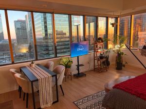 a bedroom with a desk and a television in a room with windows at Boho Studio Downtown Rogers Views Heated Parking in Edmonton