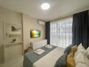 a bedroom with a large bed and a window at ESKADA Apartments in Ahtopol
