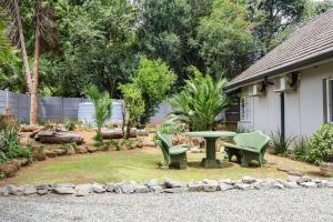 a patio with a table and chairs in a yard at Nest - The Homestead in Howick